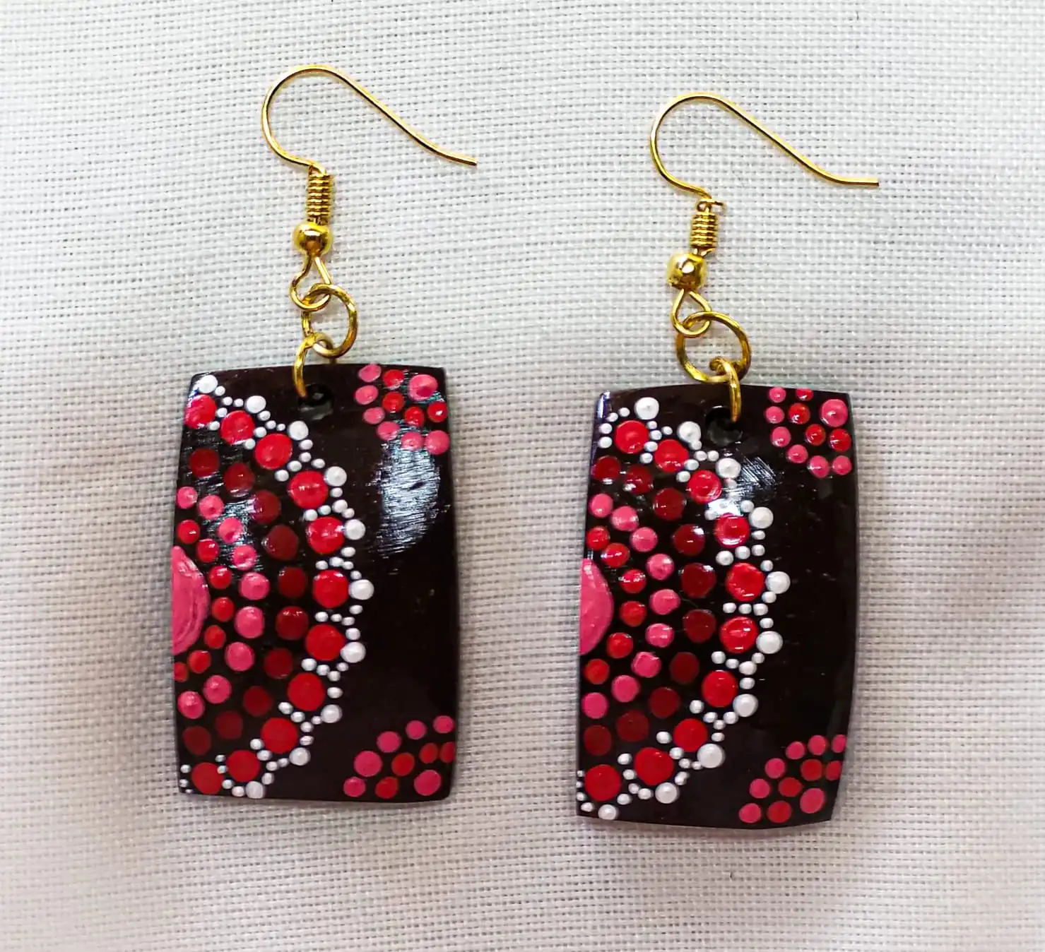 Handcrafted coconut shell earrings showing intricate Konkan patterns